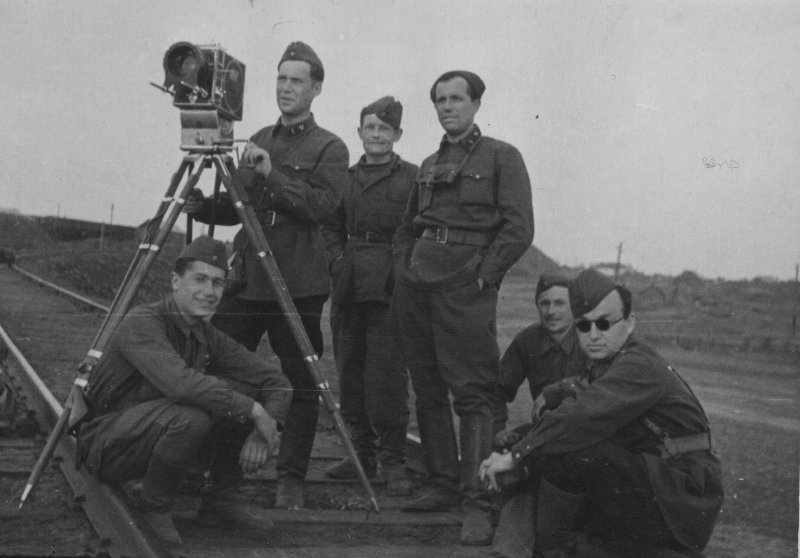 На фото фронтовые кинооператоры (слева направо): С. Стояновский, А. Левитан (за кинокамерой), М. Пойченко (четвертый слева), Д. Шоломович (справа на фото). 1942 год. Источник: ГОСКАТАЛОГ.РФ (№ 7374688).