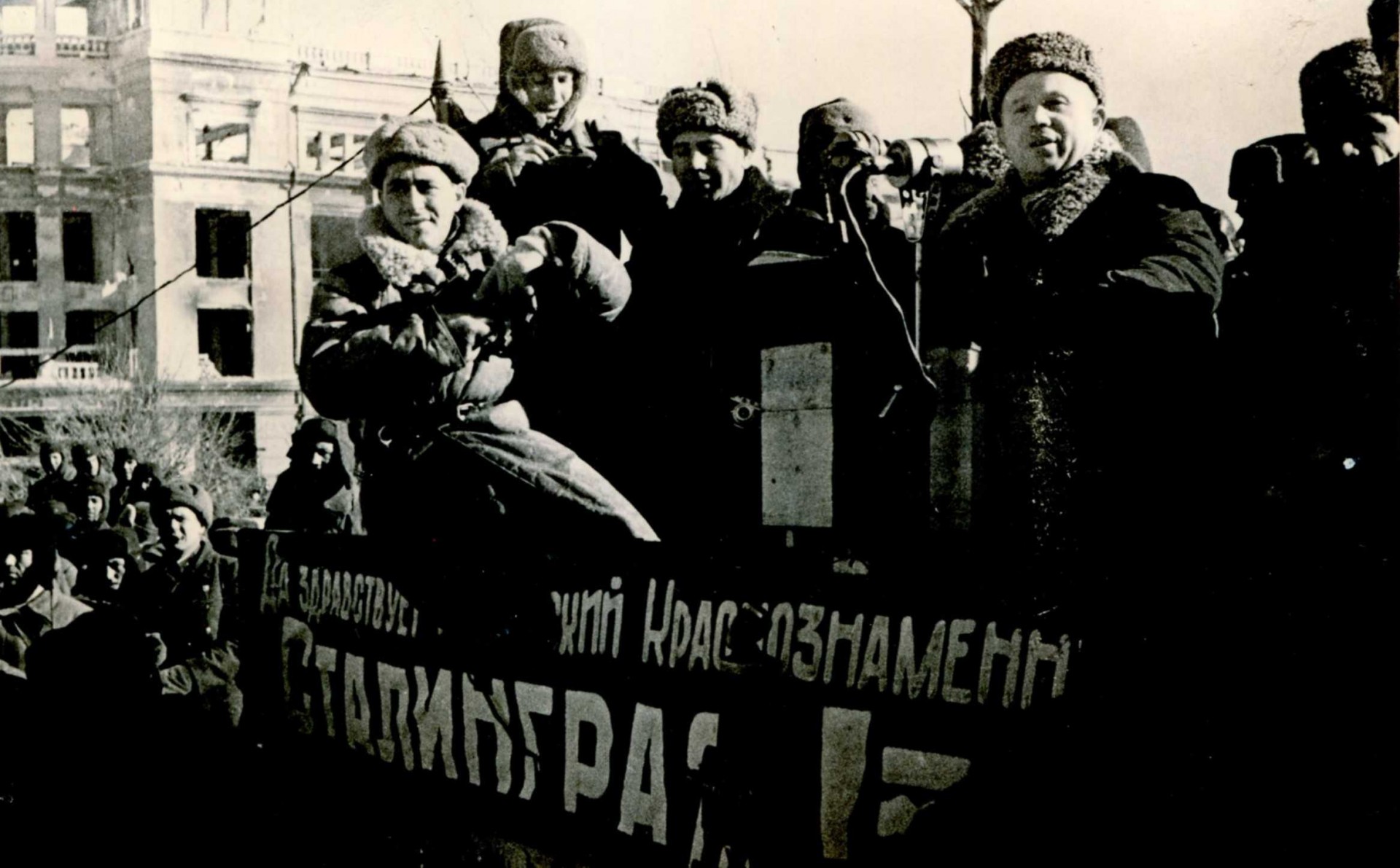 Снимает кинооператор М. Посельский (слева). Справа на трибуне Н.С. Хрущев. 04 февраля 1943 года, Сталинград. Фото из семейного архива Н.Я. Венжер.