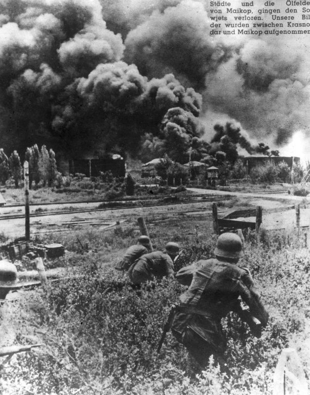 В районе Майкопа и Краснодара. Немецкие солдаты приближаются к нефтехранилищу, подожженному отступающими частями Красной Армии.